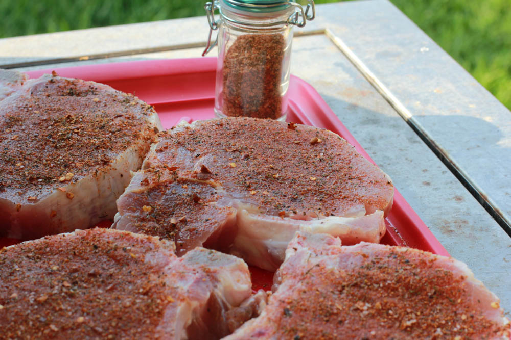 thick porterhouse pork chops with a homemade steak rub about to be grilled