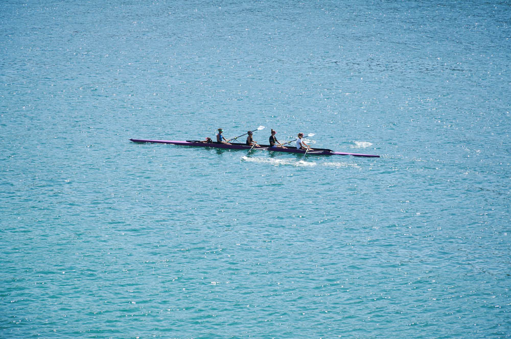 people in a row boat in the Mediterranean sea