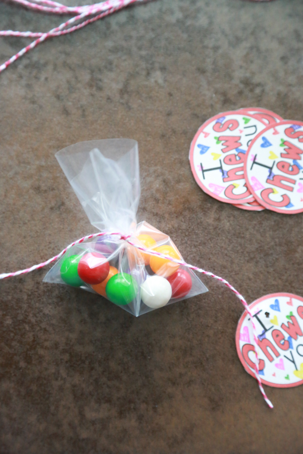 a bag of gum balls with red and white twine wrapped around it