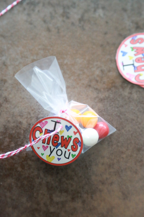 a bag of gumballs tied with red and white twine with the I Chews You printable