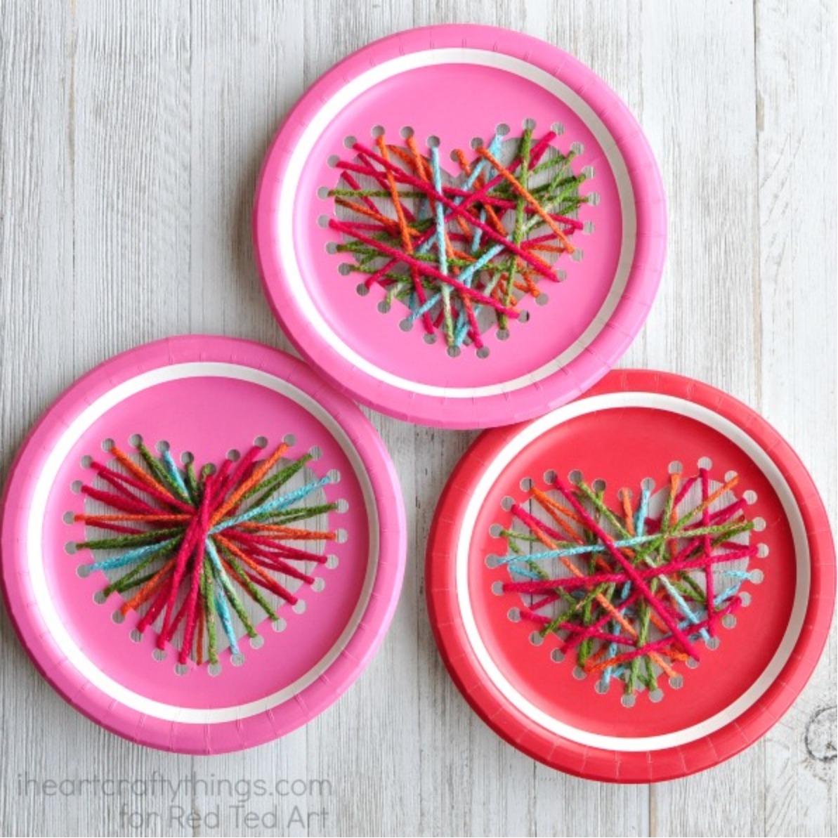 a set of three paper plates with a heart made out of yarn