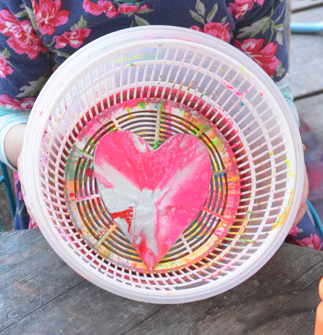 a colorful heart inside of a salad spinner after it was just spinned and painted