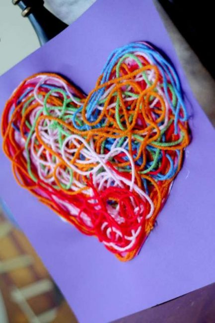 a heart made out of yarn glued onto a piece of construction paper