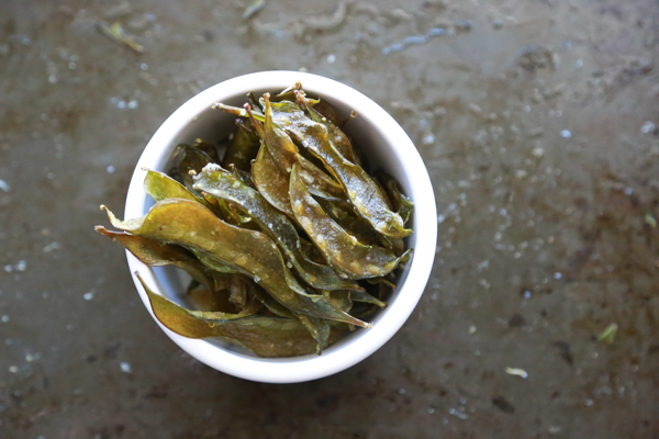 A white bowl full of appetizing homemade snap pea chips