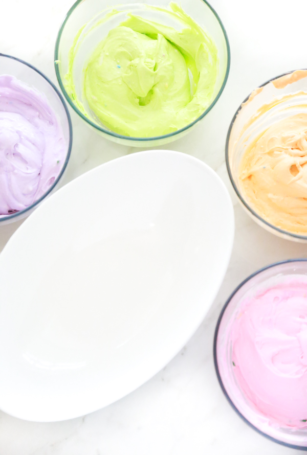 four bowls with different colored dip to make funfetti rainbow dip