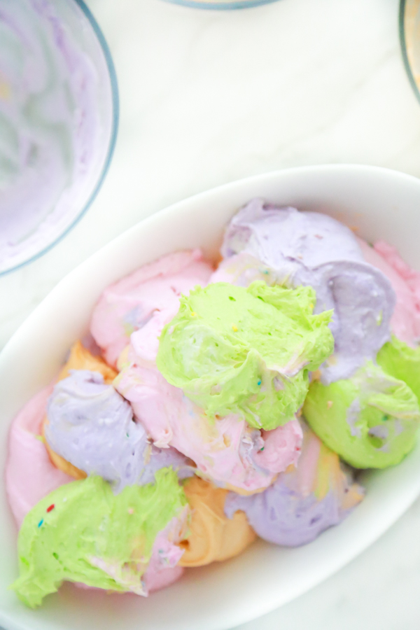 four bowls with different colored dip to make funfetti rainbow dip