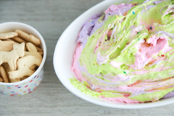 a bowl full of different colored dips to make a funfetti rainbow dip