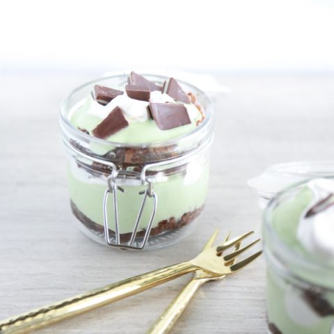 a glass jar filled with layer of brownie, cool whip and pudding to make a St. Patrick's Day Parfait