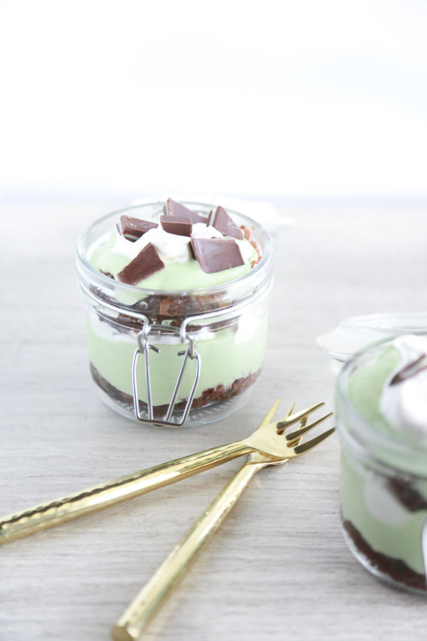 a glass jar filled with layer of brownie, cool whip and pudding to make a St. Patrick's Day Parfait