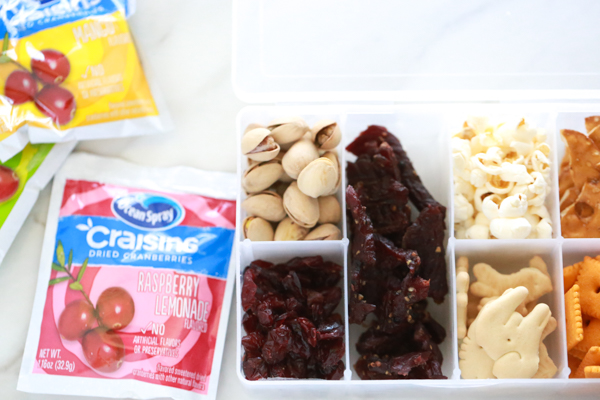 an organizer filled with snacks to make a snack box for children while on-the-go