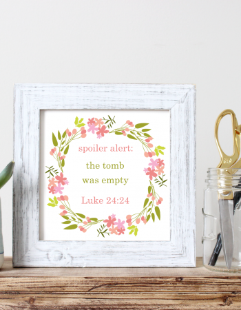 Spoiler Alert The Tomb Was Empty printable in a white fram sitting on a wood desk