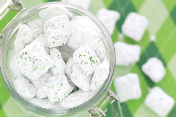 st. patrick's day puppy chow - rice chex mix covered in green candy melts, powdered sugar, and green sugar sprinkles