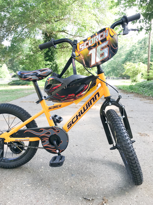 a yellow Scorch Schwinn SmartStart bike with Schwinn helmet with flames