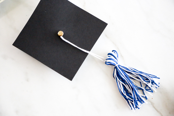 Surprise the deserving graduate with this adorable Mason Jar Graduation Hat Gift Idea filled with dollar bill diplomas.