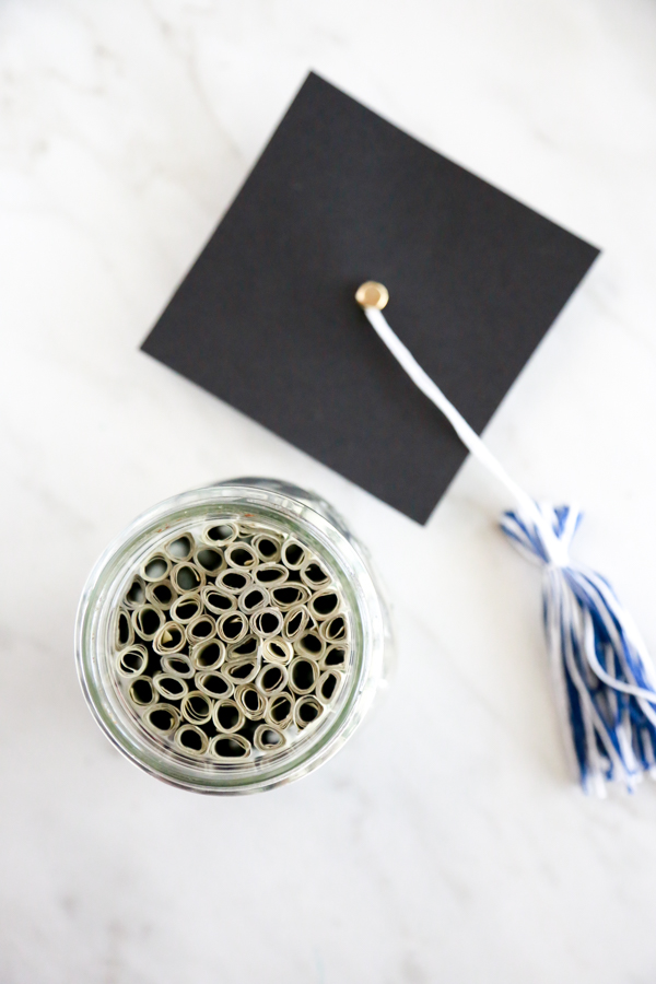 Surprise the deserving graduate with this adorable Mason Jar Graduation Hat Gift Idea filled with dollar bill diplomas.