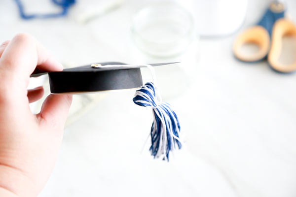 Surprise the deserving graduate with this adorable Mason Jar Graduation Hat Gift Idea filled with dollar bill diplomas.