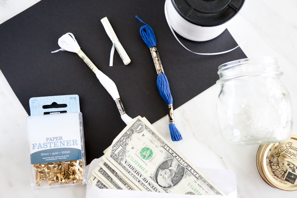 Surprise the deserving graduate in your life with this adorable Mason Jar Graduation Cap Gift Idea filled with dollar bill diplomas. Such an easy and thoughtful graduation gift idea.